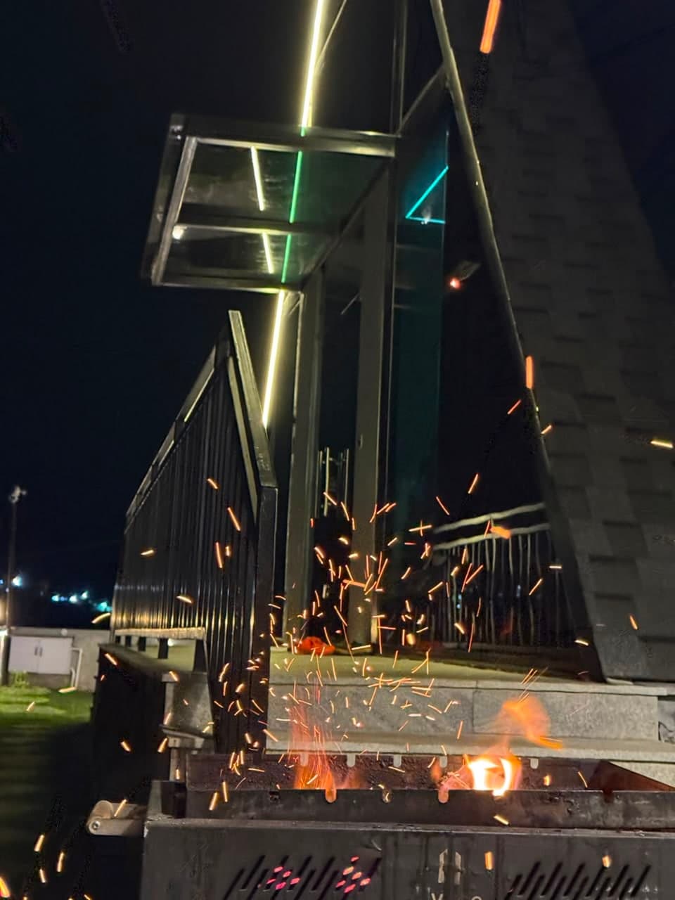 The barbecue lit, sparks over the deck